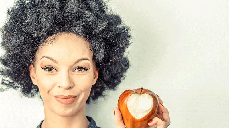 头发花白的女人在吃心形的苹果
